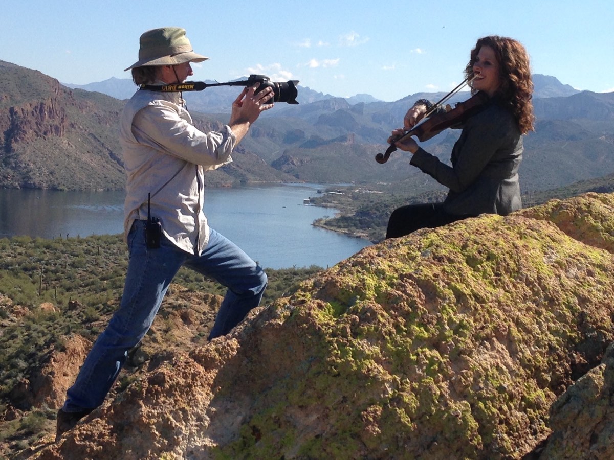 Michael Schaertl filming a Duttons violin performance at a mountain overlook